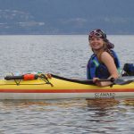 Woman in a kayak with several other kayaks in the background
