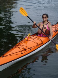 Smiling woman in an orange kayak