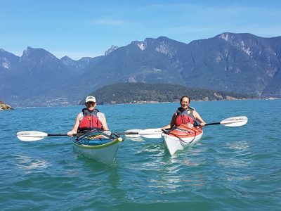 2 adults kayaking with mountain background