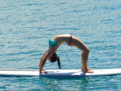Woman performing yoga on a stand up paddle board