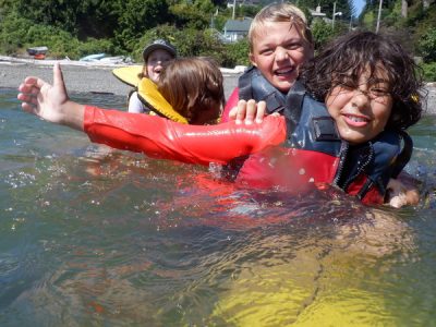 children playing on top of submerged kayak